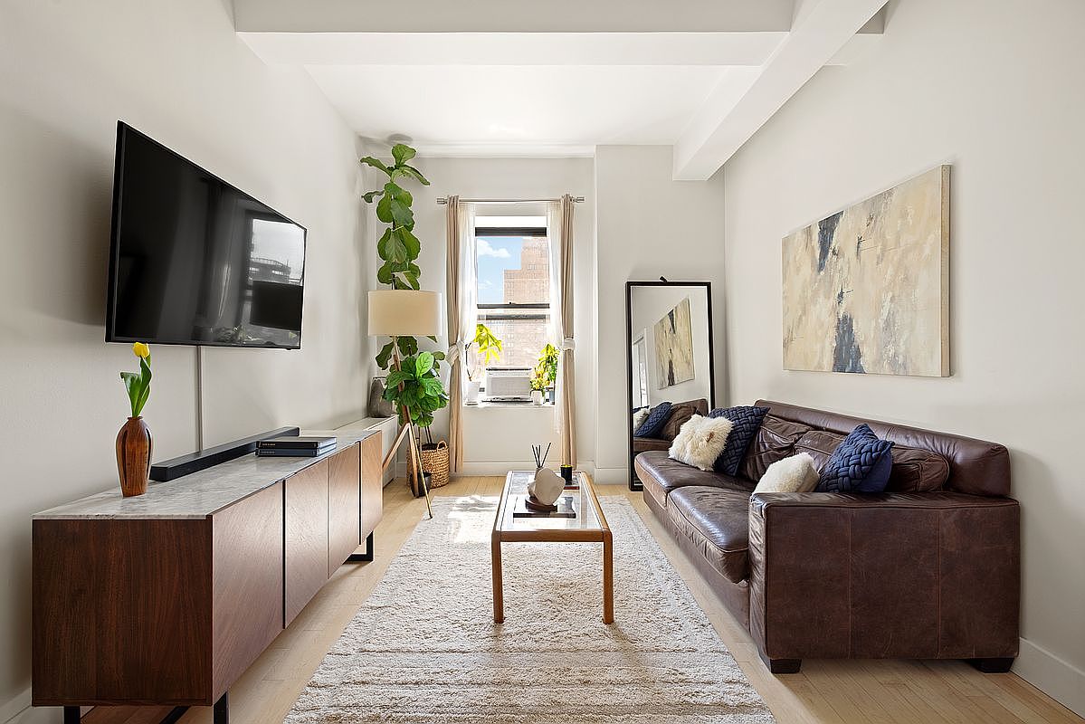 Living room with leather sofa, walnut media console, full-leaf fiddle leaf fig, abstract canvas, gauzy curtains over the east window